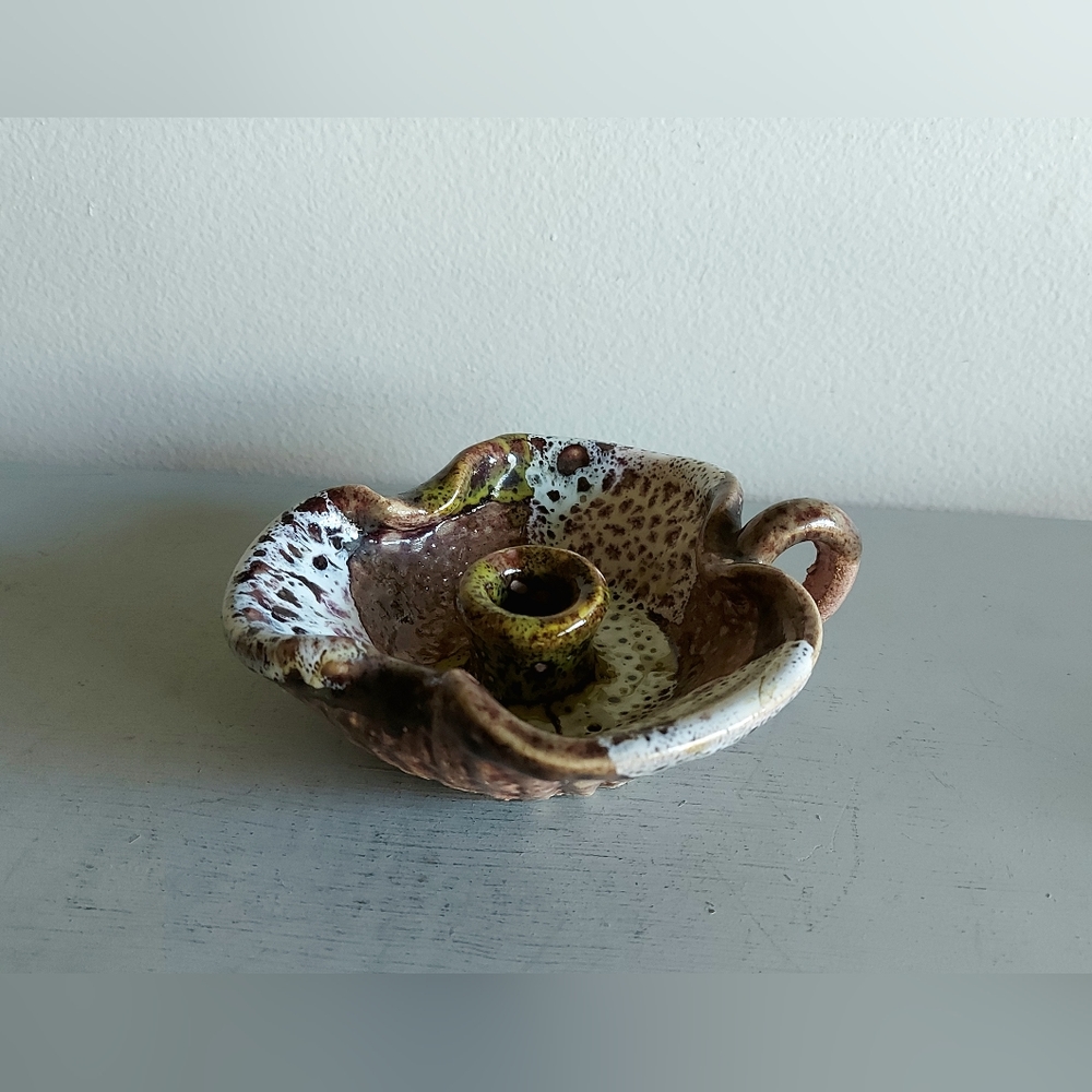Pottery handle candle holderIn shades of brown, green and white.